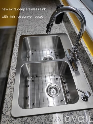 A modern kitchen sink with a high rise sprayer faucet.