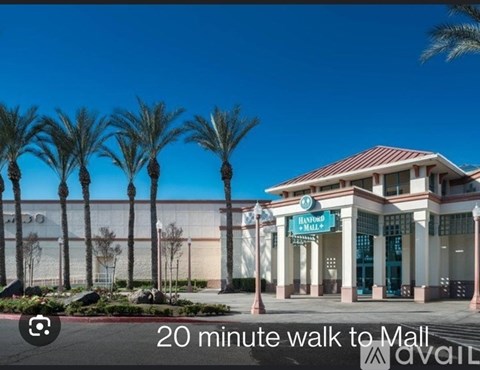 A building with a sign that says "Bonwood Mall" in front of some palm trees.