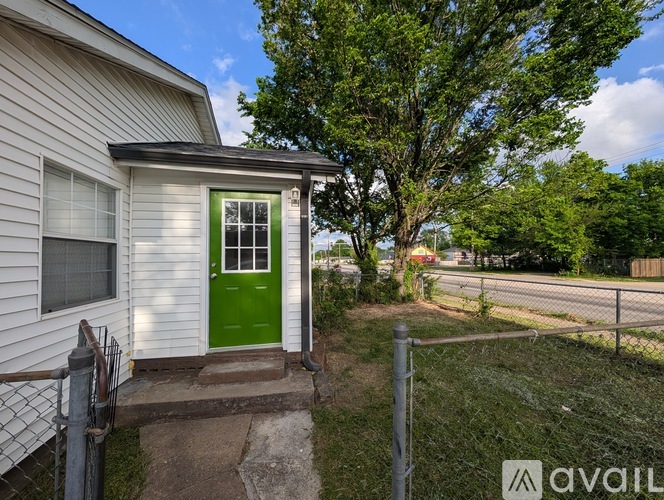 A white house with a green door is for sale.