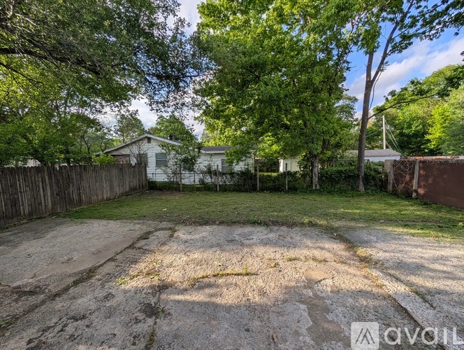 A backyard with a dirt area and trees.