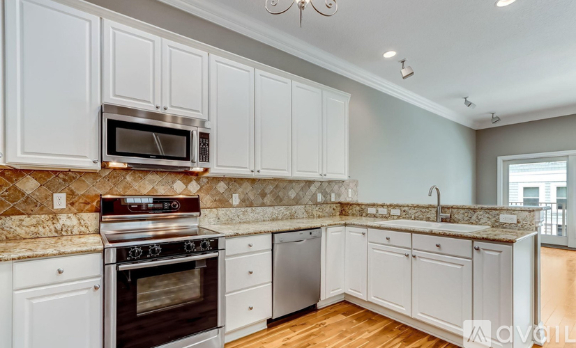 A kitchen with white cabinets and a granite countertop.