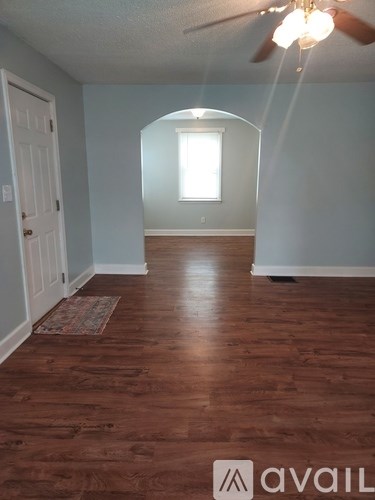 A room with wooden floors and a ceiling fan.