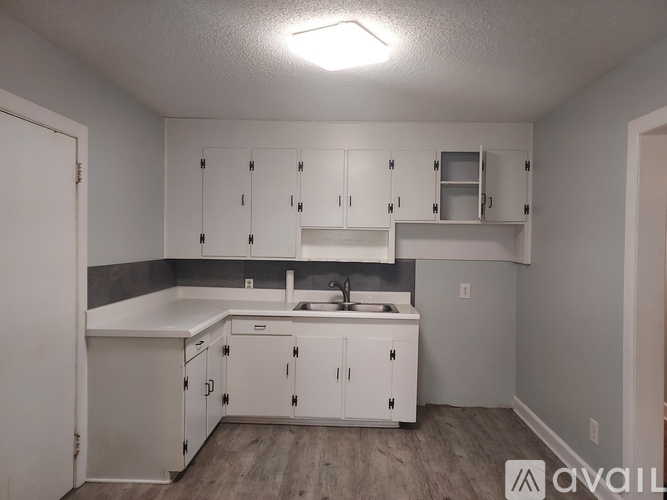 A kitchen with white cabinets and a sink.