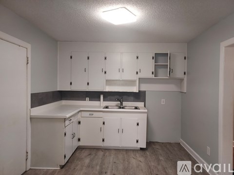A kitchen with white cabinets and a sink.