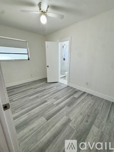 A room with a wooden floor and a ceiling fan.