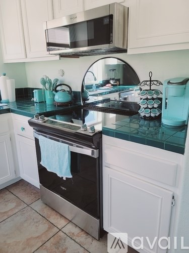 A kitchen with a black stove top oven and white cabinets.