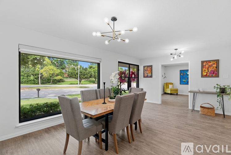 A dining room with a table and chairs and a window overlooking a street.