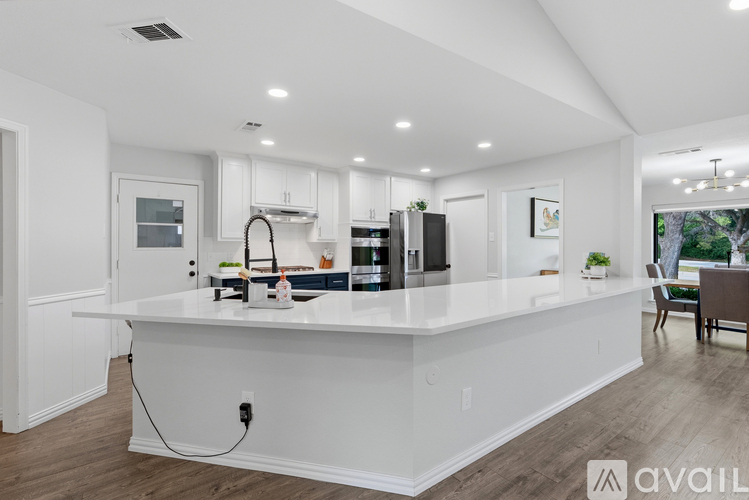 A modern kitchen with white cabinets and a large island.