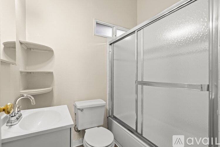 A bathroom with a toilet, sink, and shower.