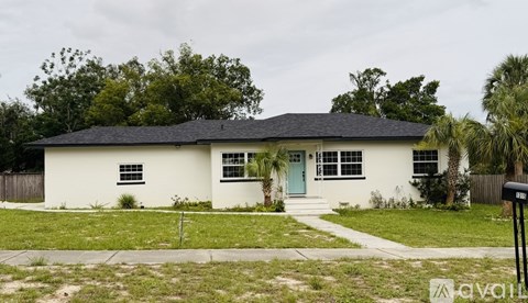 A white house with a black roof and a blue door.