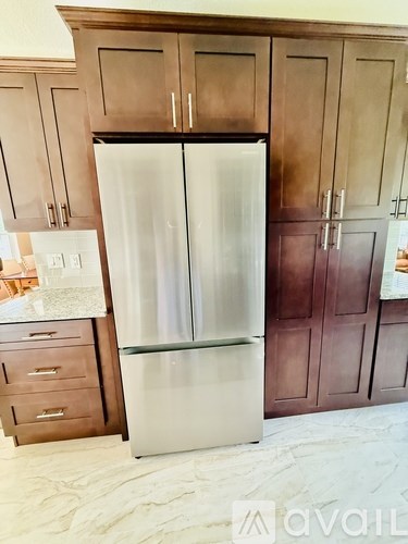 A white refrigerator in a kitchen with wooden cabinets.