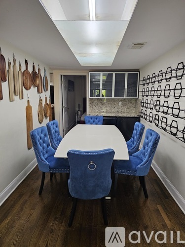 A dining room with a white table and blue chairs.