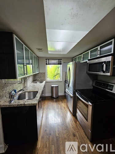 A kitchen with black cabinets and a black counter top.
