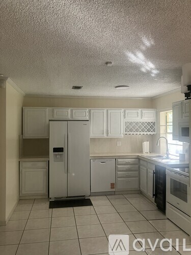A kitchen with white cabinets and appliances.