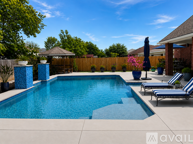 A pool with a blue water feature and a black umbrella.