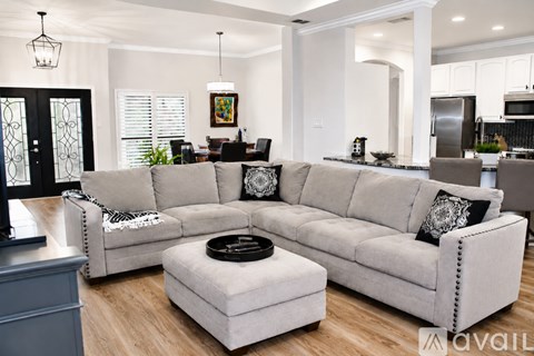 A modern living room with a large grey sectional sofa and a coffee table in the center.
