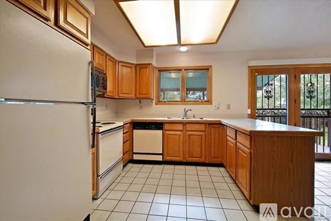 A kitchen with wooden cabinets and a white refrigerator.