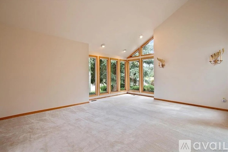 A spacious room with a large window and sliding glass doors.