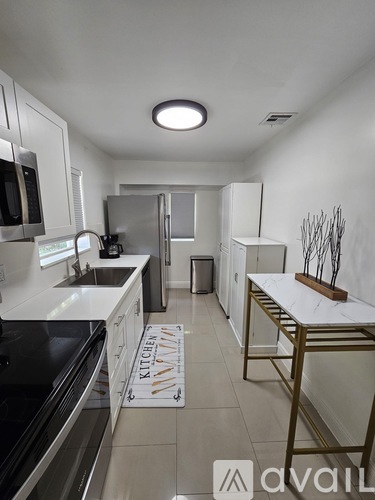 A kitchen with white cabinets and a black stove top oven.