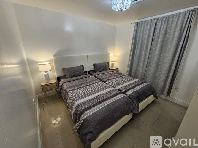A bedroom with a large bed and a chandelier.