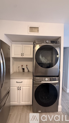 A kitchen with a stainless steel refrigerator, a dishwasher, and a washing machine.