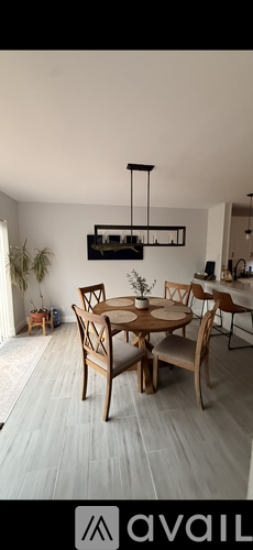 A dining room with a wooden table and chairs.