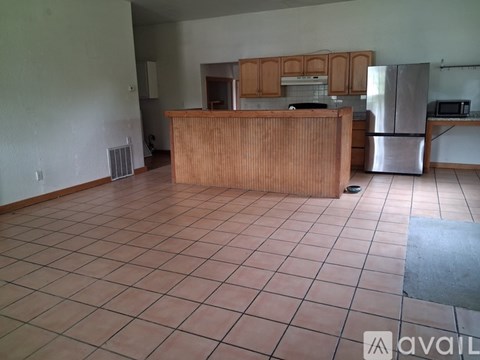 A kitchen area with a wooden counter and a refrigerator.