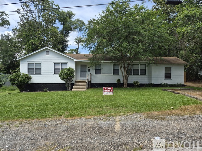 A house with a "For Sale" sign in front of it.
