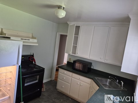 A kitchen with black appliances and white cabinets.
