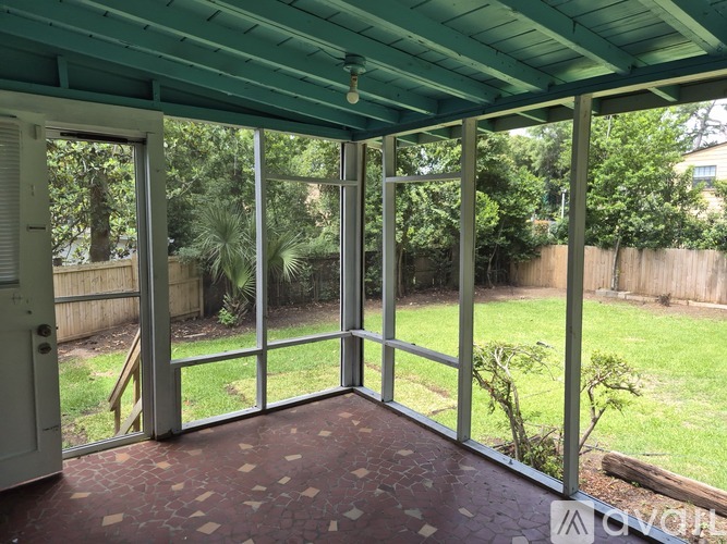 A patio with a green roof and glass doors leading to a backyard.