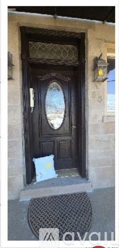 A black door with a glass window and a white bag in front of it.