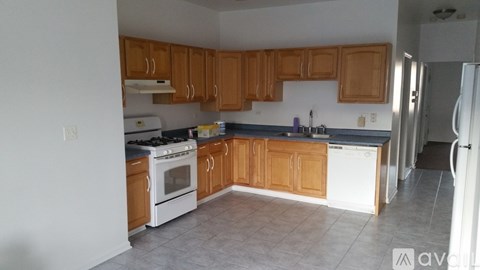 A kitchen with wooden cabinets and a white dishwasher.