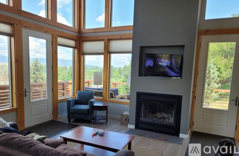 A living room with a fireplace and a television on the wall.