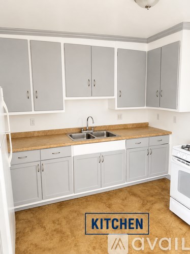 A kitchen with white cabinets and a brown countertop.