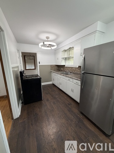 A kitchen with a refrigerator, stove, and cabinets.