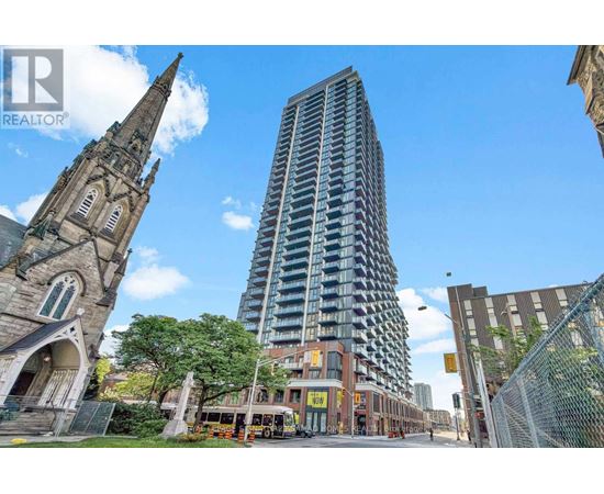 A tall building stands in front of a church and a bus.