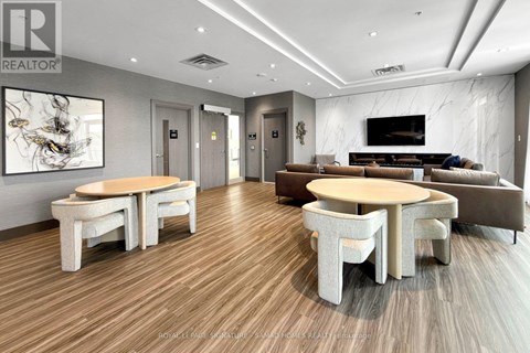 A modern living room with a wooden floor and a large painting on the wall.