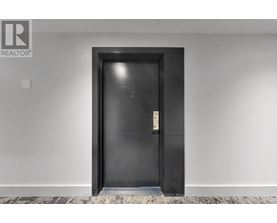 A black door with a silver handle in a white room.