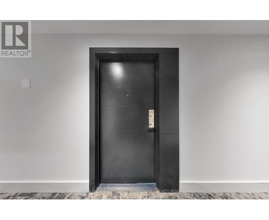 A black door with a silver handle in a white room.