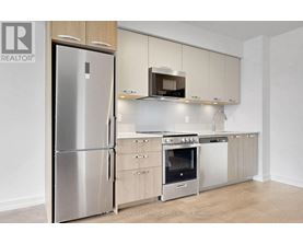 A modern kitchen with a stainless steel refrigerator and a microwave oven.