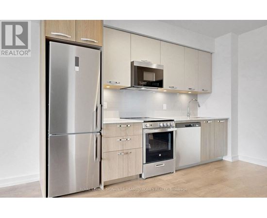 A modern kitchen with a stainless steel refrigerator and a microwave oven.