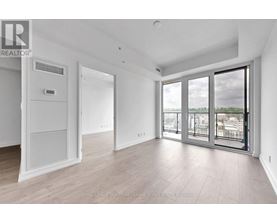 A spacious room with a sliding glass door leading to a balcony.