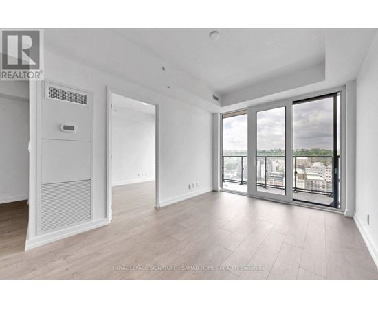 A spacious room with a sliding glass door leading to a balcony.
