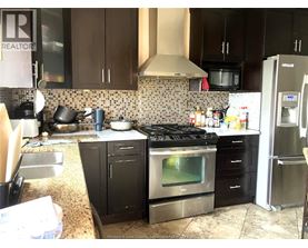 A kitchen with a black stove top oven and black cabinets.
