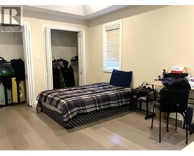 A bedroom with a bed, desk, and chair.