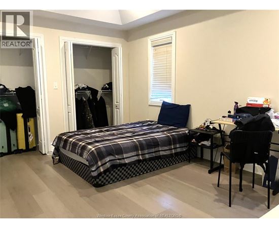 A bedroom with a bed, desk, and chair.