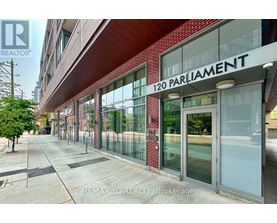 A building with a glass facade and a sign that reads "120 PARLIAMENT".