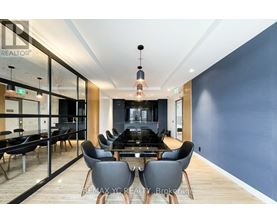 A modern dining room with a glass wall and a wooden floor.