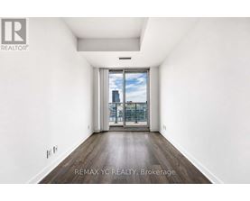 A spacious, empty room with a view of the city through a large window.