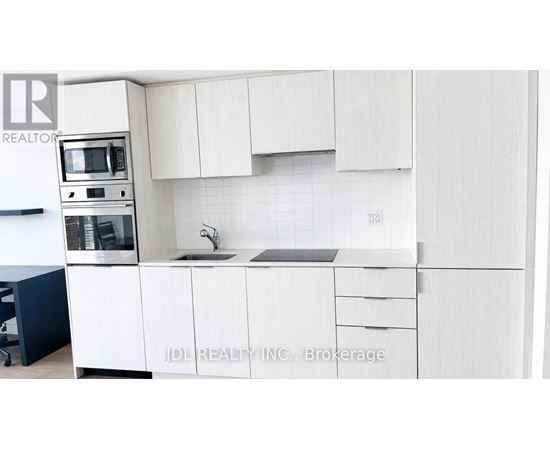 A kitchen with white cabinets and appliances.